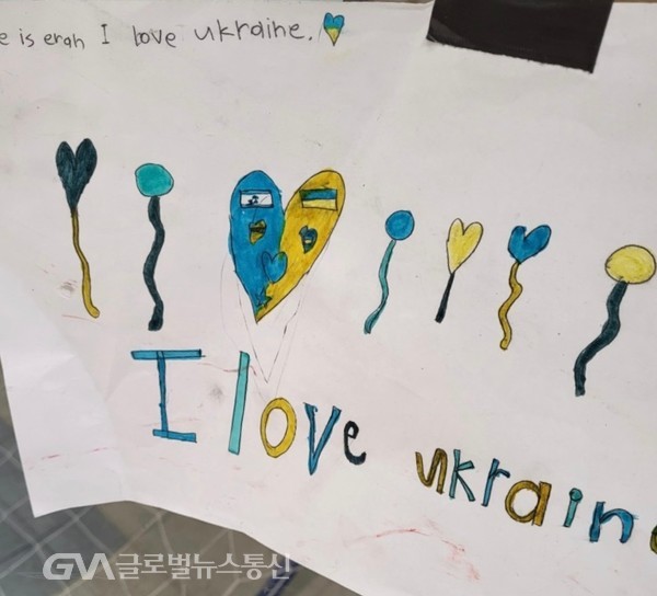 (사진제공: 우크라이나 Jane Nam) 난민보호소 생활을 하는 어린이들을 위한 교실에서, 어린이들이 그린 집합그림, 나라사랑이 배어 있다. 