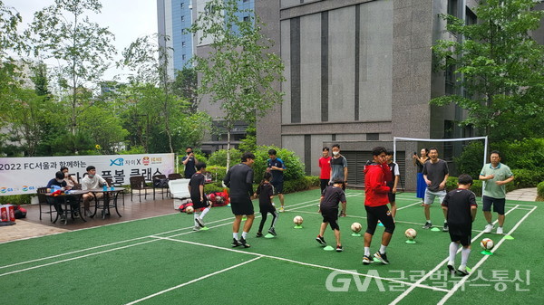 (사진제공:GS건설) 지난 7월 24일 서울 마포구에 위치한 신촌그랑자이 아파트에서 진행된 ‘FC서울과 함께하는 찾아가는 풋볼클래스’ 행사에 참여한 입주민들이 축구 기술을 배우고 있다